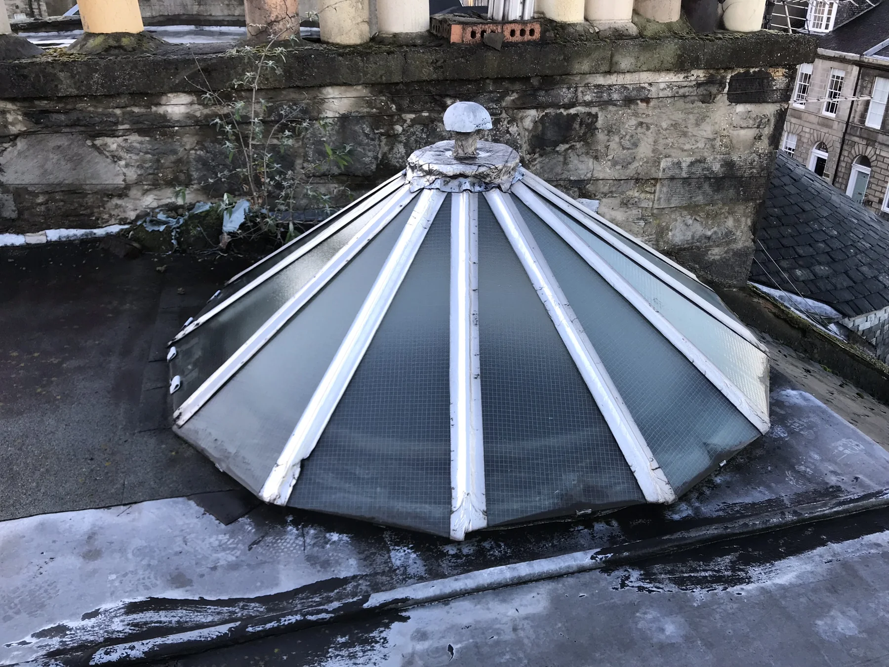 Glazed roof cupola set into a flat roof behind stone parapet walls at Albany Street, Edinburgh