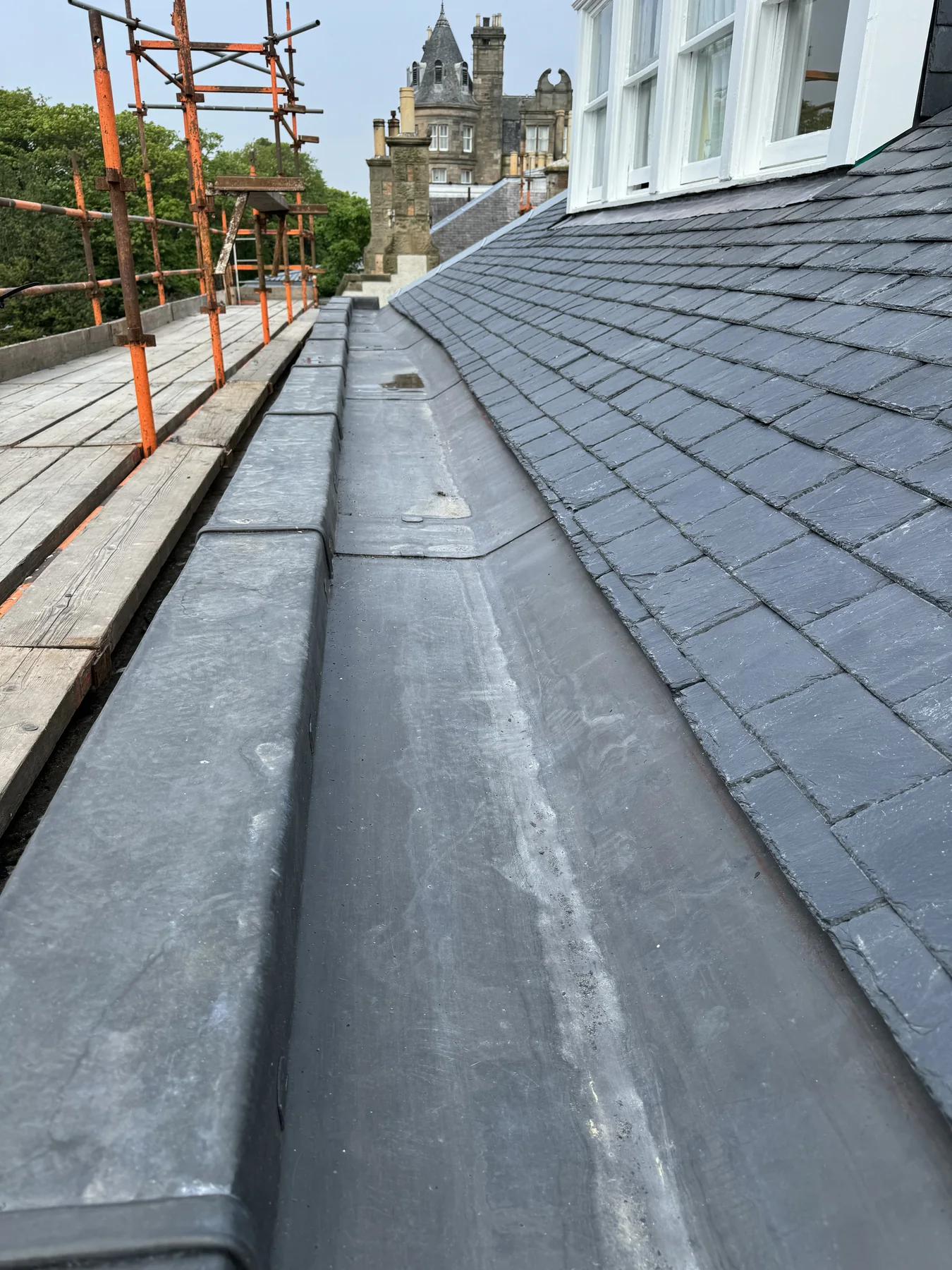 Newly formed lead gutter running alongside a natural slate roof at Cromwell Road, Edinburgh